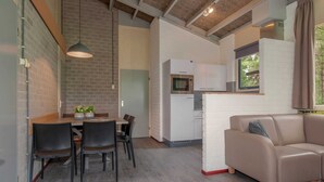 Un espace de vie compact comprenant un coin repas, une kitchenette et un canapé.