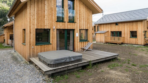 A wooden cabin with a deck and a hot tub. - Deluxe Chalet With Whirlpool (Sankt Georgen am Kreischberg)