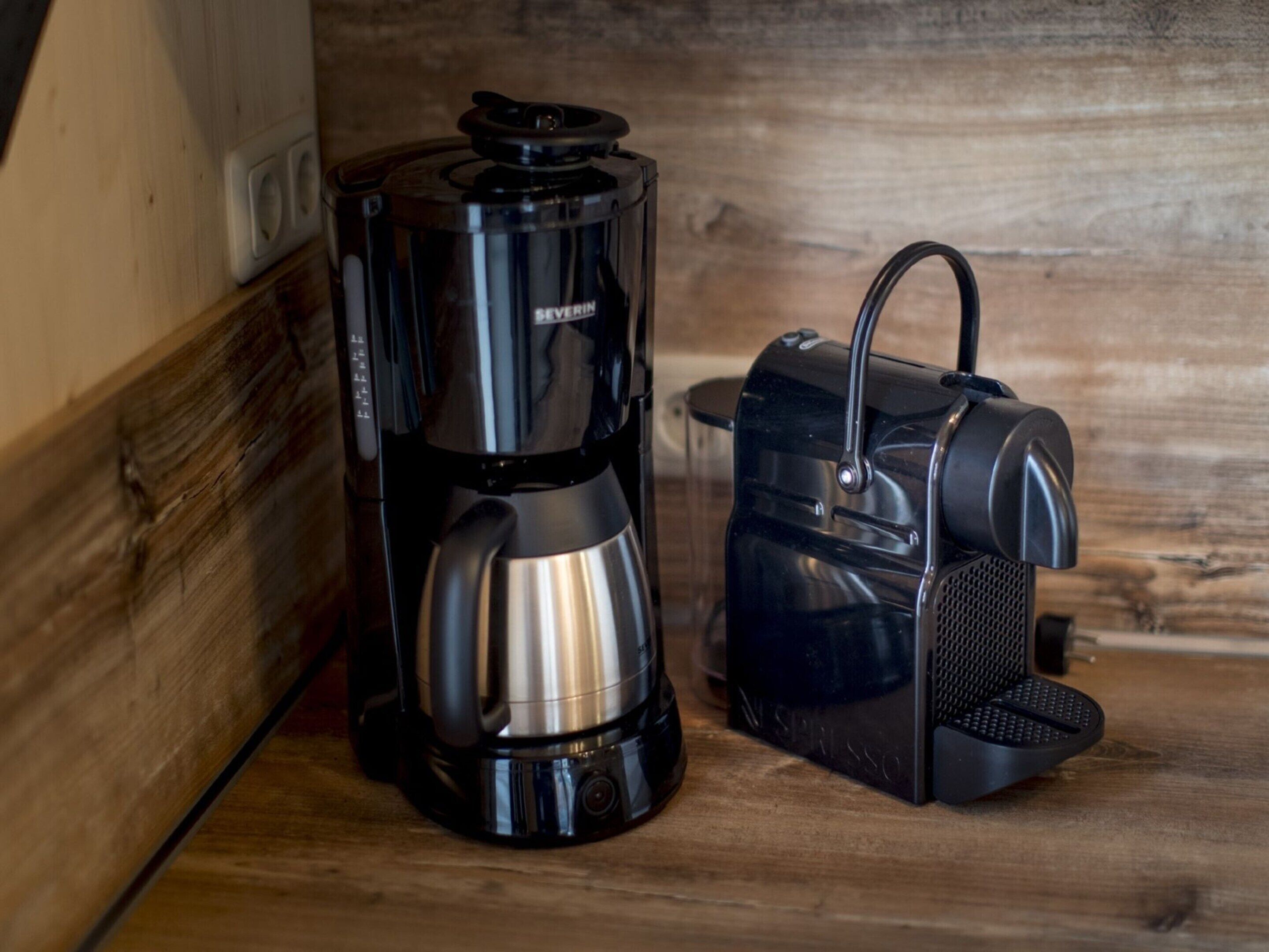 A coffee maker and a toaster on a wooden surface.