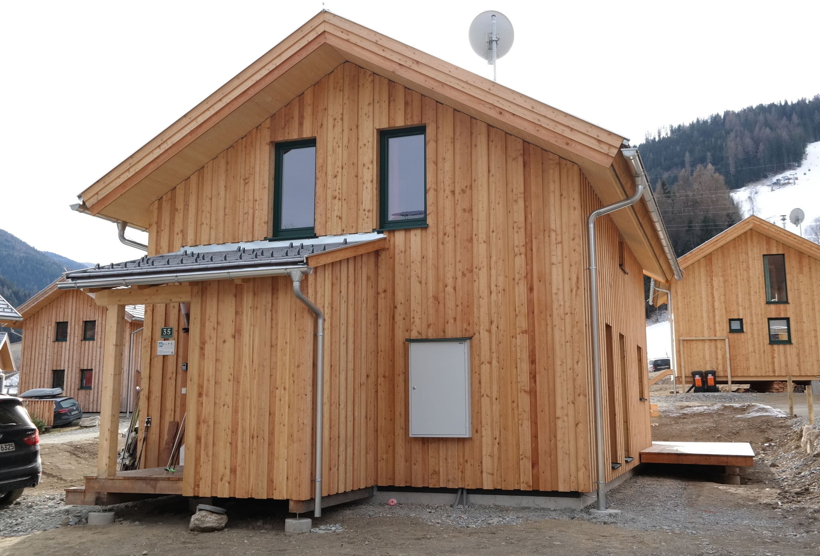 Eine Holzhütte mit geneigtem Dach, einer Satellitenschüssel und einer kleinen Veranda.