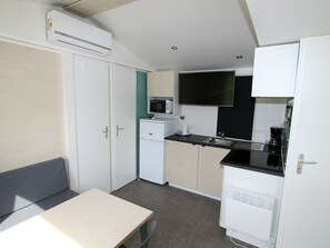 A compact kitchenette with a microwave, coffee maker, and a small refrigerator.