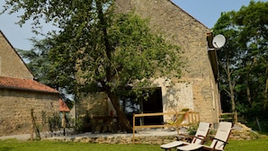 A stone building with a large tree in front, a wooden deck, and two lounge chairs. - Holiday Home Near Opal Coast Wierre-effroy (Wierre-Effroy)
