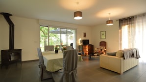 A living room with a sofa, a table with chairs, a fireplace, and a television. - Holiday Home Near Opal Coast Wierre-effroy (Wierre-Effroy)