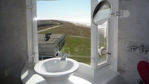 Un baño con lavabo, espejo y ventana.