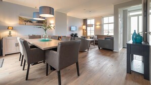 A modern living room with a dining area, a sofa set, and a TV mounted on the wall. - Holiday Home in Colijnsplaat by the Lake (Colijnsplaat)