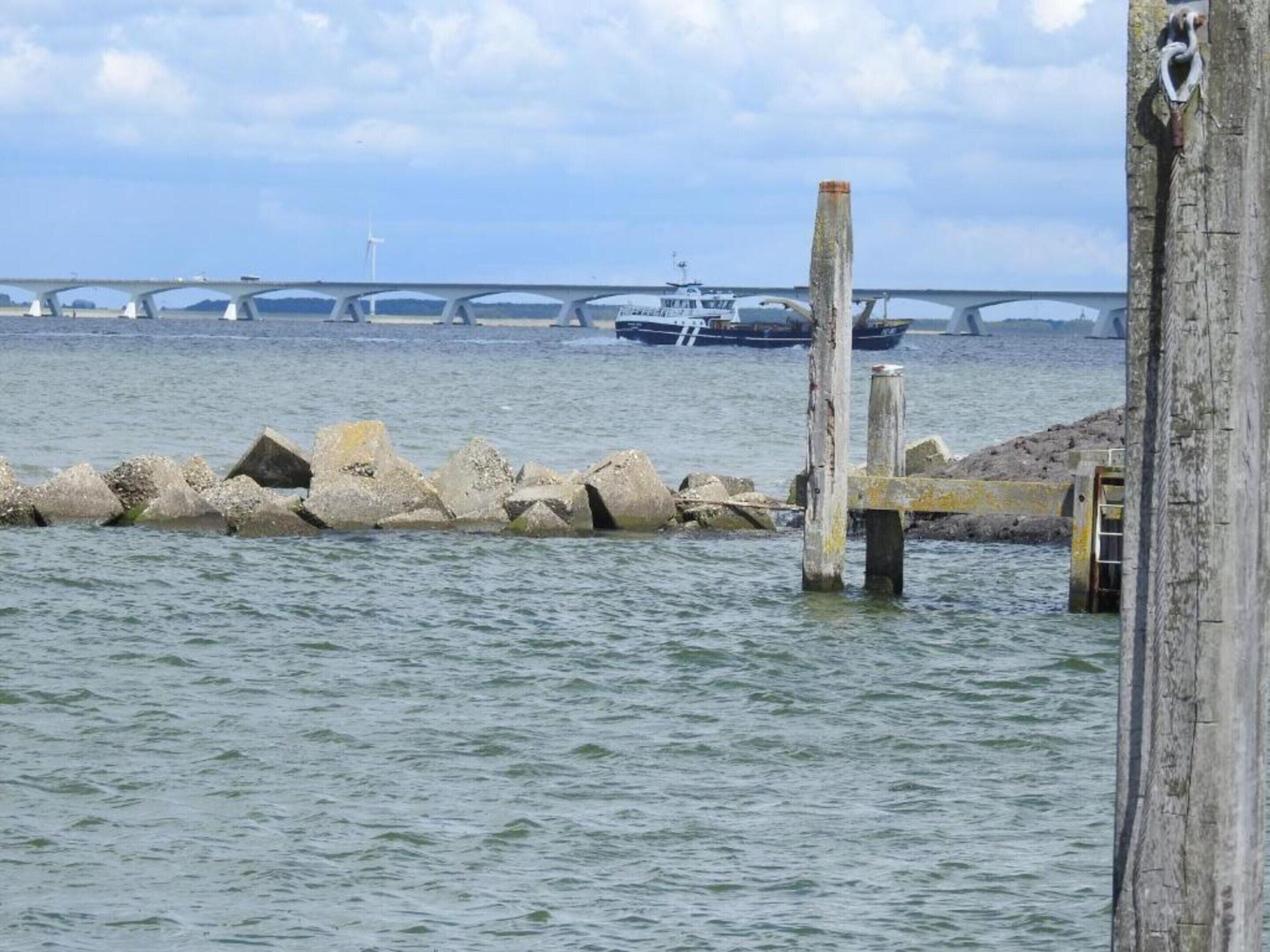 Une vue sur le front de mer, avec un pont, des bateaux et une jetée en bois.
