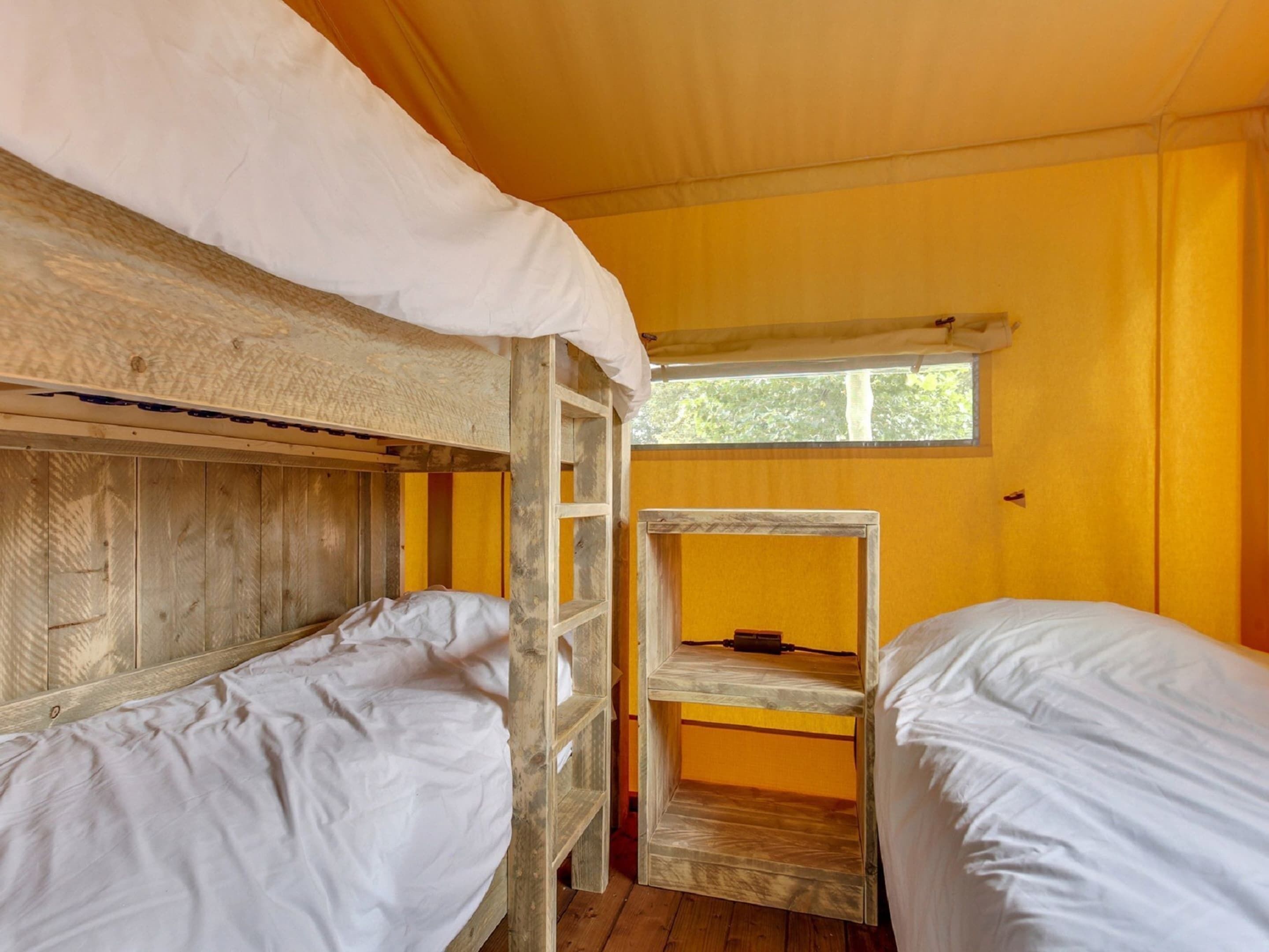 Quarto com duas beliches, paredes de madeira, janela e escada.
