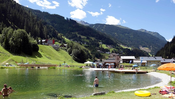 A lakeside village with houses, a dock, and a swimming area. - Apartment Near the Lake in Tyrol (Kappl)