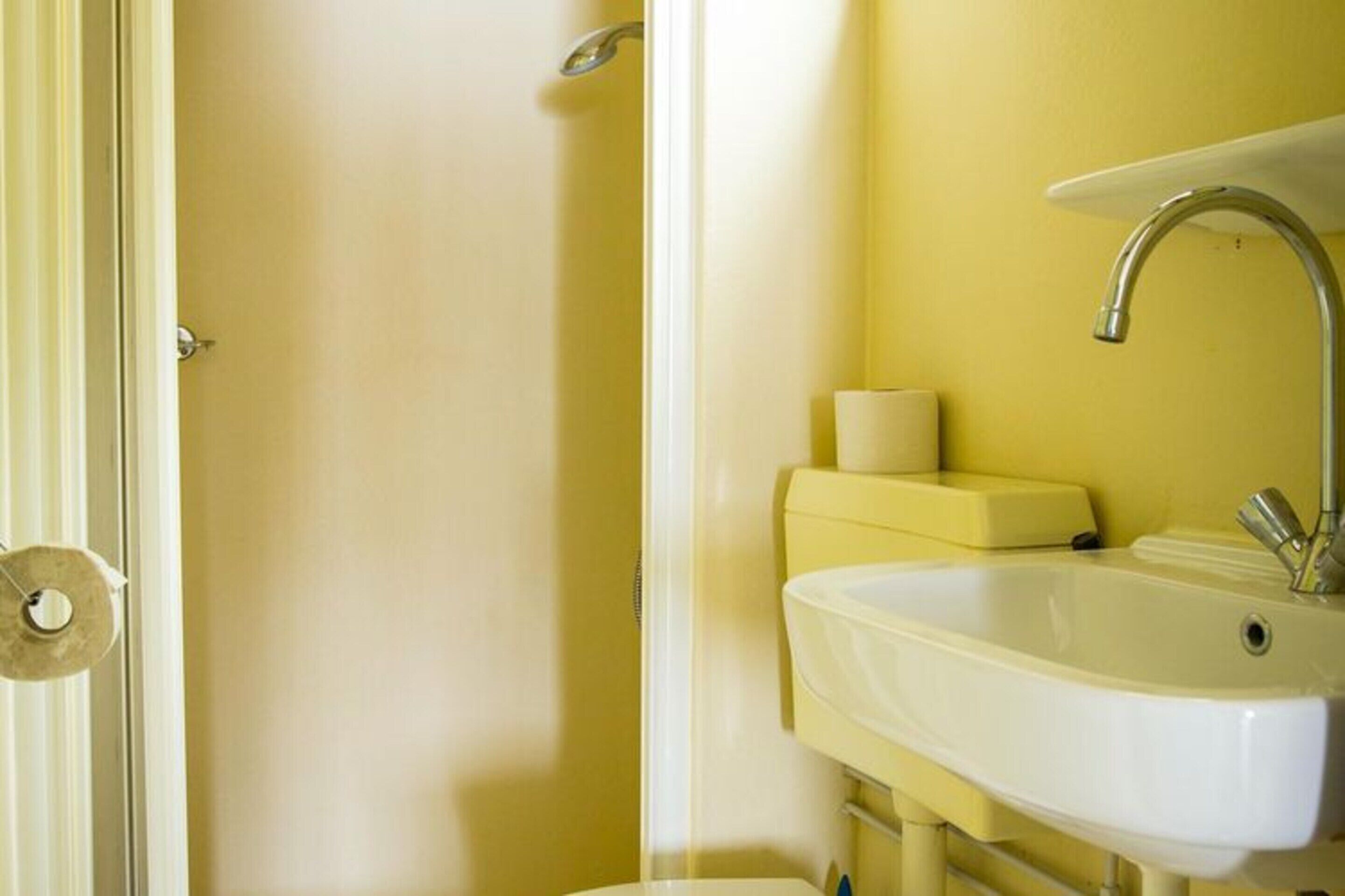 Un bagno con un lavandino bianco, uno specchio e un water.