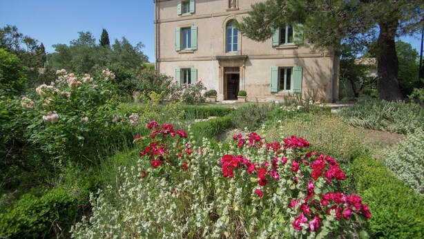 A two-story building with a symmetrical facade, a central entrance, and a well-maintained garden with flowering plants. - Mansion in Fournes With Private Pool (Fournes)