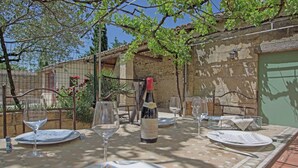 An outdoor dining area with a table set for two, a bottle of wine, and wine glasses. - Mansion in Fournes With Private Pool (Fournes)