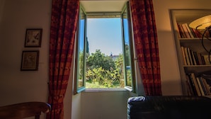 A room with a window, curtains, a bookshelf, and a chair. - Mansion in Fournes With Private Pool (Fournes)