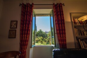 A room with a window, curtains, a bookshelf, and a chair. - Mansion in Fournes With Private Pool (Fournes)