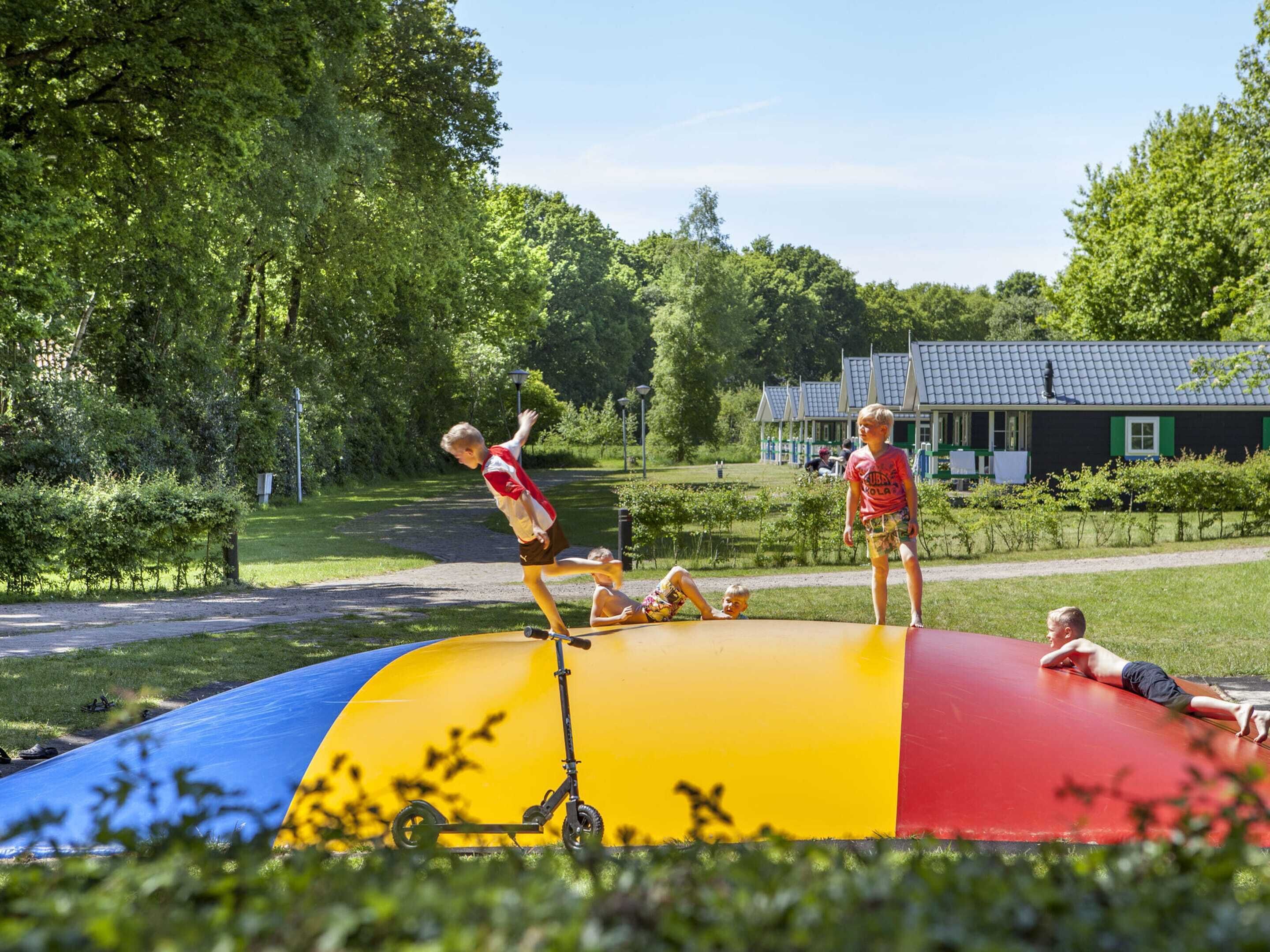 Un parque infantil con un tobogán colorido y un patinete.