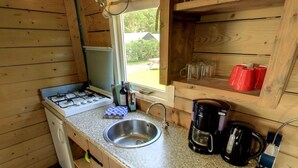 A compact kitchen with a gas stove, stainless steel sink, and a coffee maker. - Glamping With Comfort in Ijhorst (IJhorst)