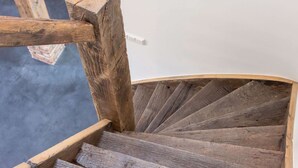 Un escalier en colimaçon en bois, doté d’une main courante et de marches.