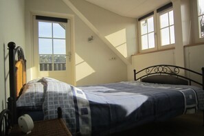 A bedroom with a bed, a window, and a door. - Lovely Cottage near Lake in Well (Well)