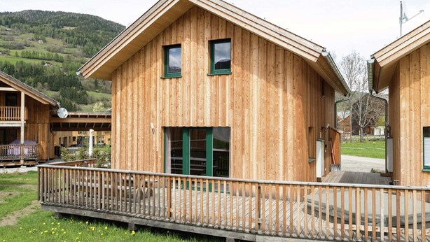 Une cabane en bois dotée d’un balcon, d’une terrasse couverte et offrant une vue sur le paysage environnant.