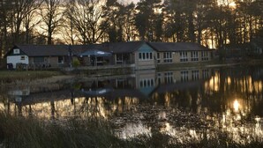 A lakeside building with a reflection in the water, surrounded by trees. - Unique Holiday Home in Stramproy near Forest (Stramproy)