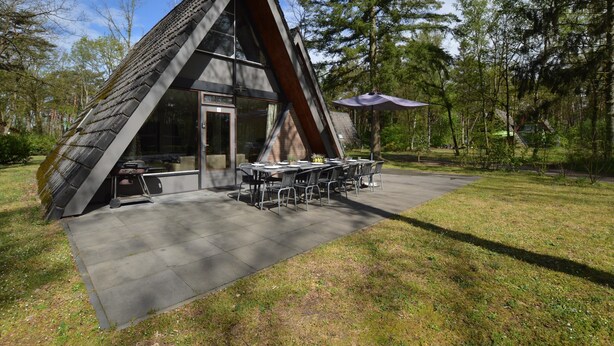 A modern, triangular-shaped building with a dining area and outdoor seating. - Unique Holiday Home in Stramproy near Forest (Stramproy)