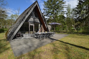 Un edificio moderno de forma triangular, con comedor y terraza.