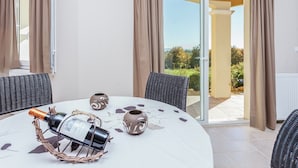 A room with a round table, a bottle of champagne, and two decorative vases. - Villa in Cazals With Pool & Lake Nearby (Cazals)
