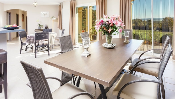 A dining area with a table, chairs, and a vase of flowers. - Villa in Cazals With Pool & Lake Nearby (Cazals)