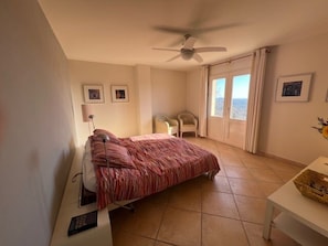 A bedroom with a bed, a ceiling fan, a chair, a table, and a window with curtains. - Elegant Villa With Pool, Cabris (Cabris)