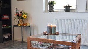 Ein Holztisch mit Glasplatte, Kerze und Zeitschrift.