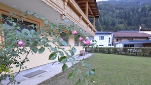 A building with a wooden balcony and a grassy yard. - Apartment in Oetz Near Ski Lift (Oetz)