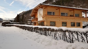 A two-story building with a balcony, surrounded by snow and trees. - Apartment in Oetz Near Ski Lift (Oetz)