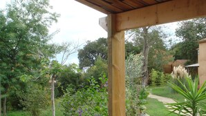 A wooden pergola structure with a garden view. - Villa in Poggio-mezzana Near the Sea (Poggio-Mezzana)