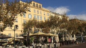 An outdoor cafe with tables and chairs, a building with arched windows, and a clear sky. - Villa in Poggio-mezzana Near the Sea (Poggio-Mezzana)