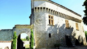 A stone building with a central archway, a small window, and a door.