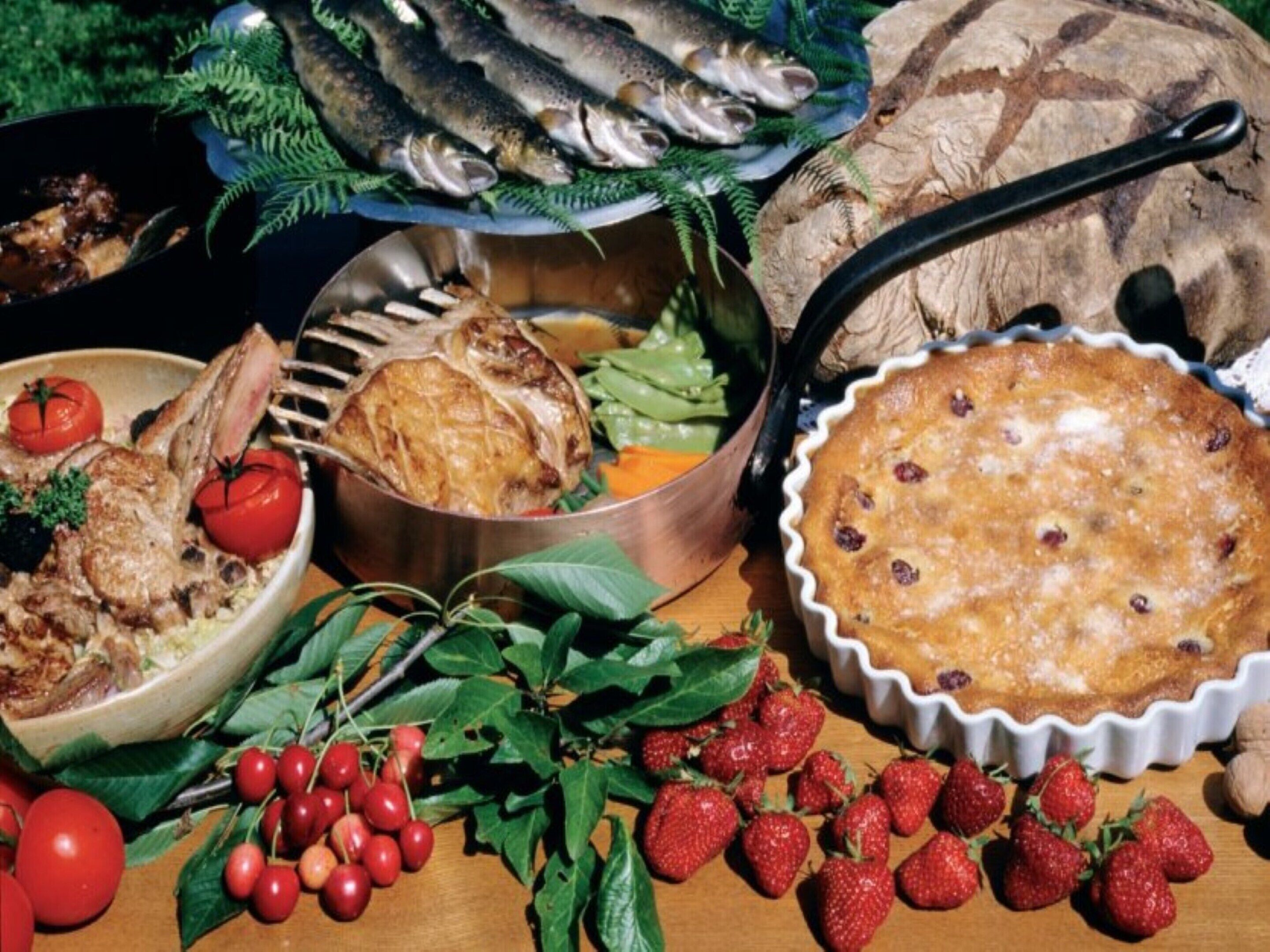 A variety of food items including fish, a pie, and fresh berries.