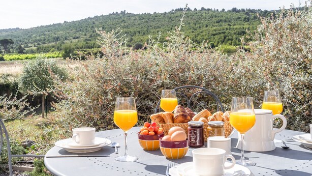 Mesa de desayuno al aire libre con vista a un paisaje montañoso.