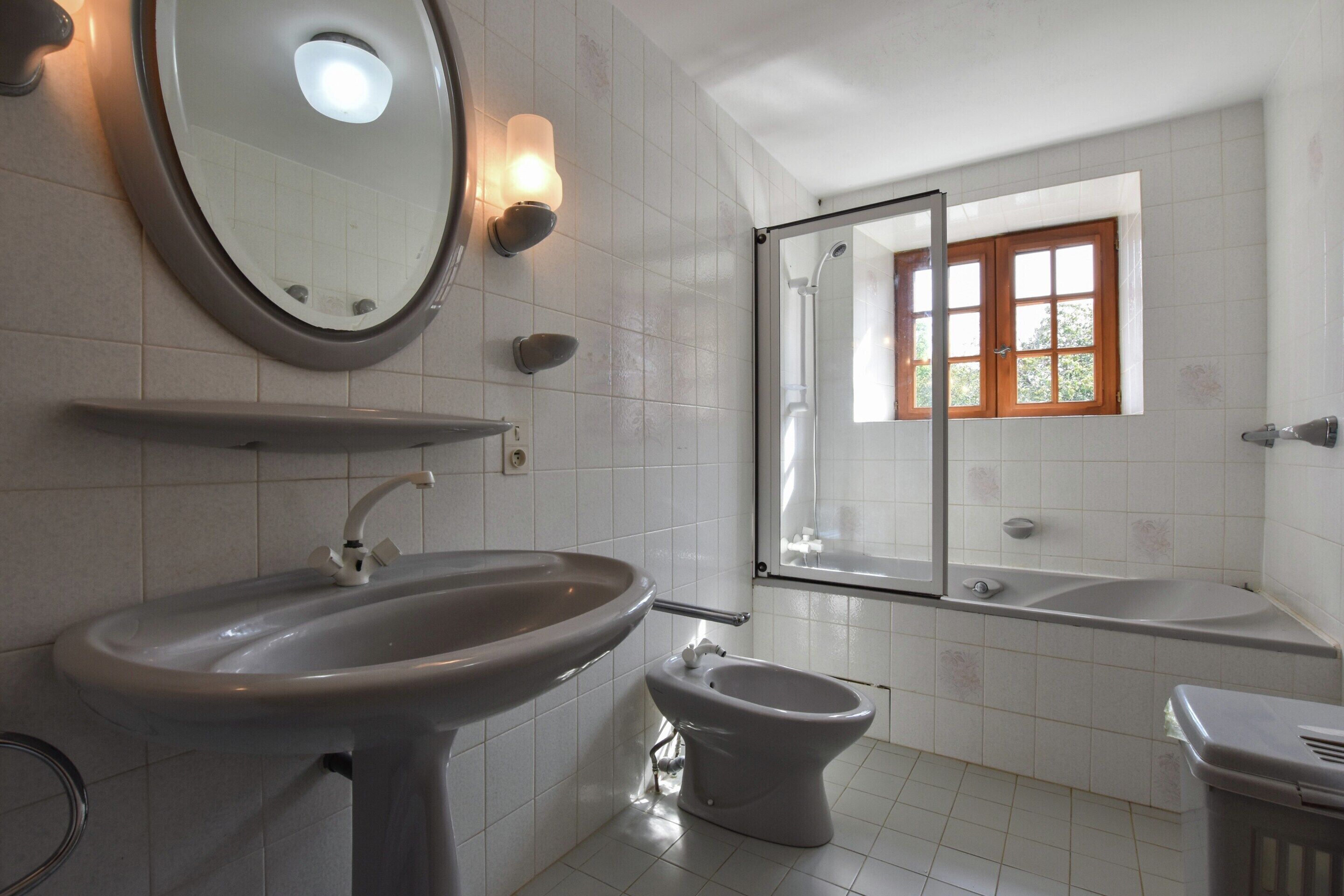 A bathroom with a sink, toilet, bidet, and bathtub.
