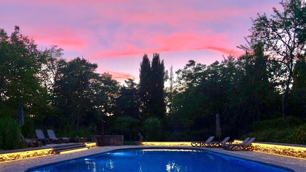 A swimming pool with lounge chairs and a stone pathway. - Holiday Home in Dordogne Near Lascaux Cave (Les Eyzies)