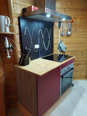 A kitchen with a wooden countertop, a built-in oven, and a wall-mounted knife rack. - Chalet in Vosges Near Ski Slopes (Saint-Maurice-sur-Moselle)