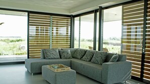 A modern living room with a grey sectional sofa, a matching ottoman, and a wooden tray table. - House Boat in Goengahuizen With Sauna (Goengahuizen)