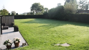 A well-maintained lawn with a wooden deck and potted plants. - Groet Villa Stay With Garden Views (Groet)