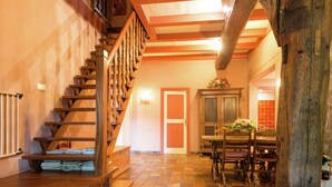A wooden staircase leading to a dining area with a tiled floor and a wooden table with chairs. - Secluded Farmhouse in Balkbrug with Hot Tub (Balkbrug)