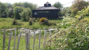 A rustic wooden building with a sign reading "Pannassia." - Holiday Home Bergen Near Beach & Dunes (Bergen aan Zee)