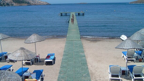 A beach with a pier extending into the sea, lounge chairs, and umbrellas. - Family-friendly Villa With Pool (Roquebrune-sur-Argens)