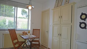 A dining area with a table, chairs, and a window with blinds.
