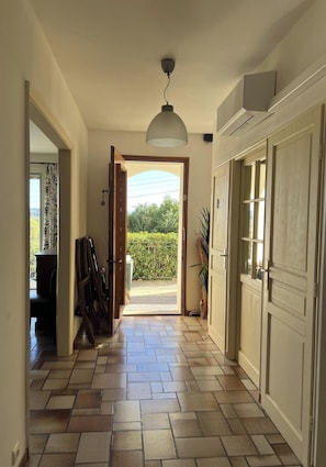 A hallway with a tiled floor, a ceiling light, and a door leading to an outdoor area. - Apartment With Panoramic View, Swimming Pool and spa (Carcassonne)