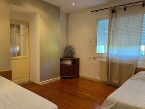 A room with wooden flooring, a bed with striped bedding, a window with blinds, and a radiator. - Spacious Villa Retreat in Carcassonne (Carcassonne)