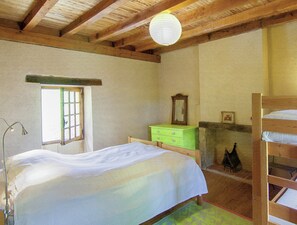 A room with a bed, a dresser, a mirror, and a window. - Hilltop Home With Valley View (Bouzic)