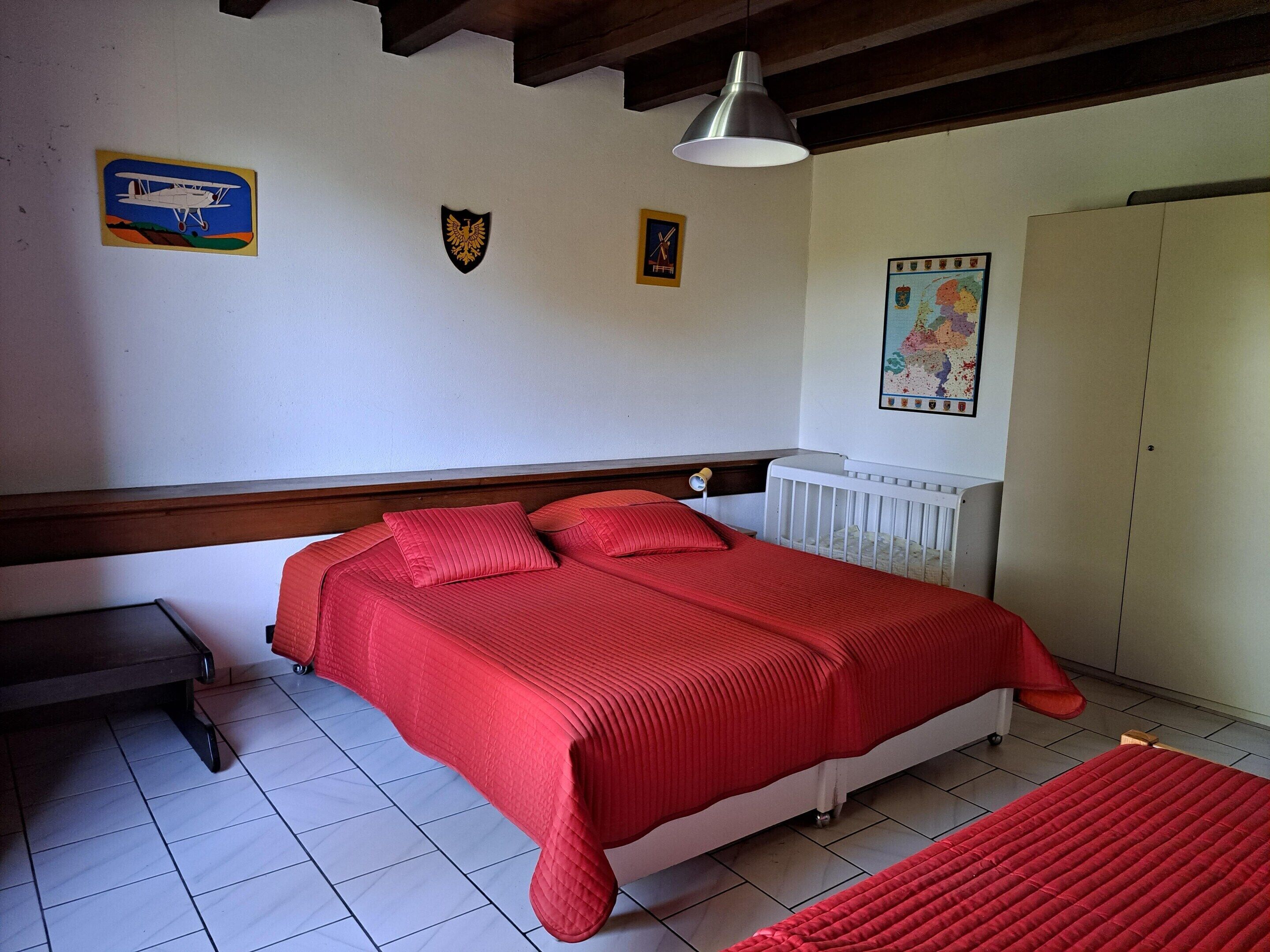 A bedroom with a bed, a radiator, a wardrobe, and a map on the wall.