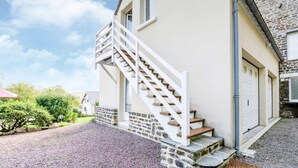 A house with a stone facade, a white staircase, and a garage.